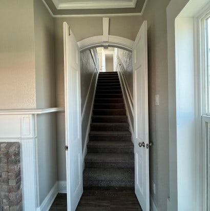 stairway featuring hardwood / wood-style flooring and ornamental molding