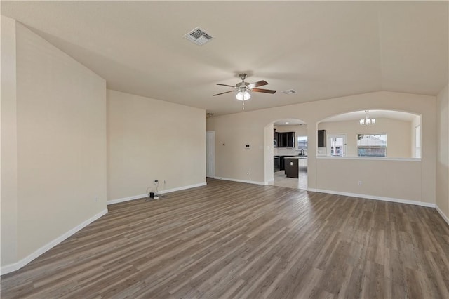 unfurnished living room featuring ceiling fan with notable chandelier, hardwood / wood-style flooring, and lofted ceiling