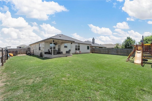 rear view of property featuring a playground, ceiling fan, a patio area, and a lawn