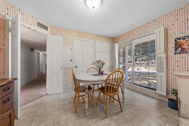 dining room with visible vents, brick patterned floor, and wallpapered walls