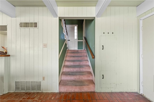 staircase with beam ceiling and visible vents