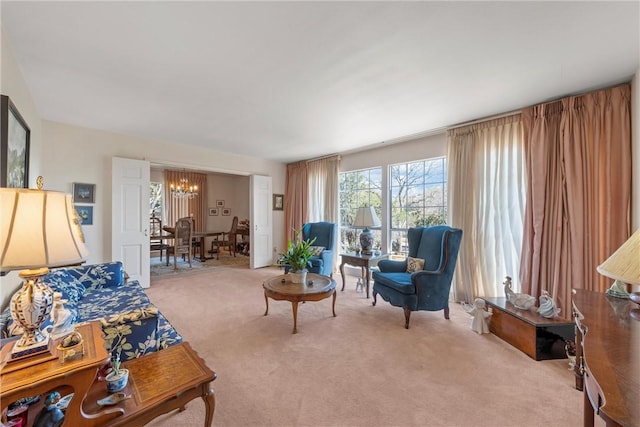 carpeted living area with a chandelier