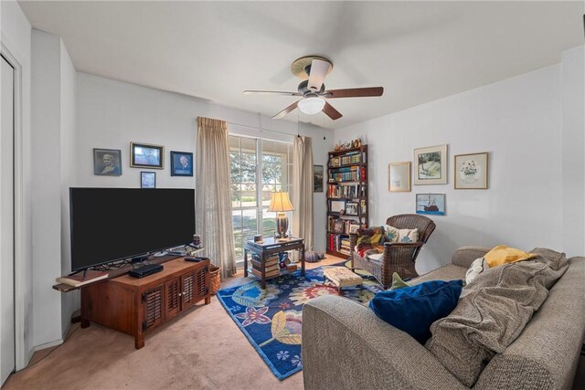 living area featuring light carpet and a ceiling fan