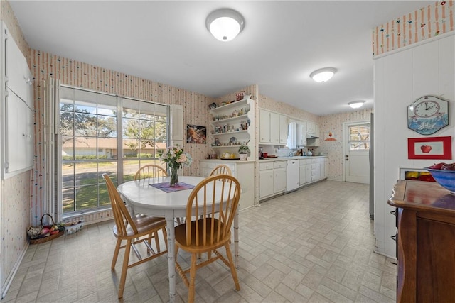 dining room with wallpapered walls, baseboards, and brick patterned floor