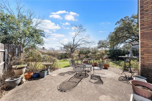 view of patio featuring outdoor dining space and fence