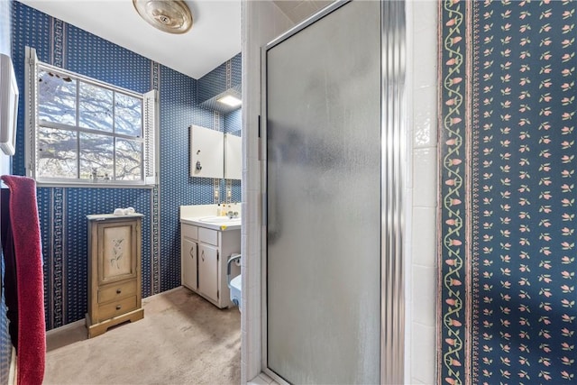 full bath with a shower stall, wallpapered walls, and vanity