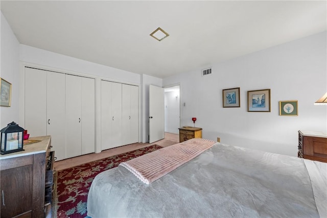 bedroom featuring visible vents and two closets