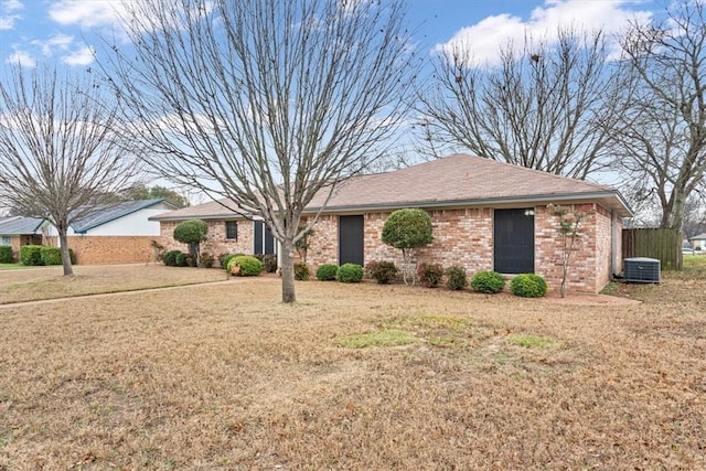 ranch-style home featuring central AC and a front yard