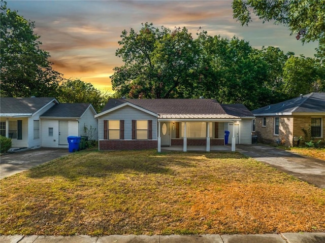 single story home featuring a porch and a lawn