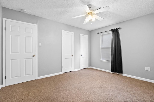 unfurnished bedroom with ceiling fan, carpet floors, and a textured ceiling