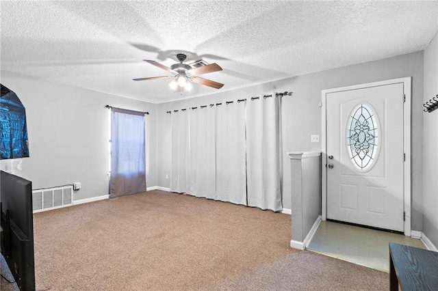 carpeted foyer featuring ceiling fan and a textured ceiling