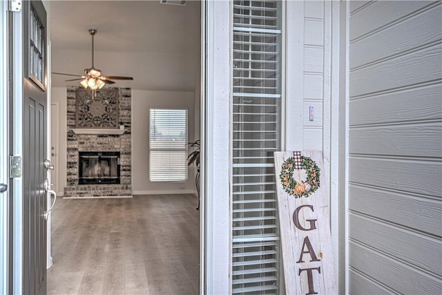 interior space featuring a brick fireplace and ceiling fan