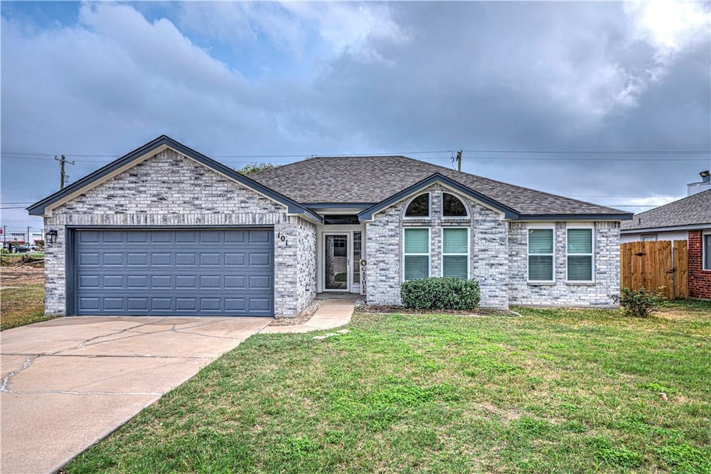 single story home featuring a front yard and a garage