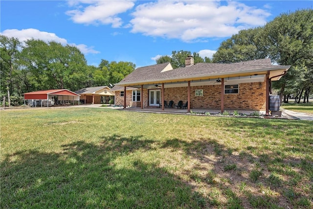 rear view of property with ceiling fan, a yard, and french doors