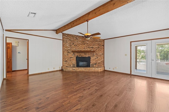 unfurnished living room featuring french doors, a brick fireplace, vaulted ceiling with beams, ceiling fan, and wood-type flooring