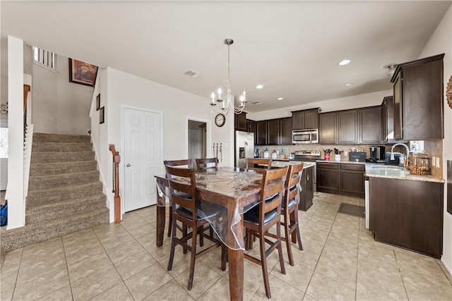 tiled dining area featuring a notable chandelier and sink