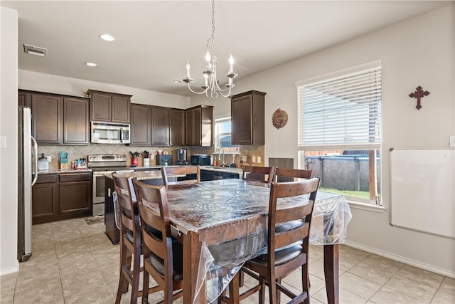 tiled dining area featuring a chandelier and sink