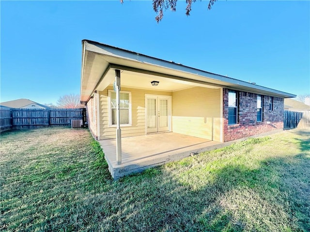 rear view of property featuring a lawn, a patio, and central air condition unit