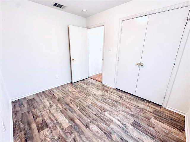 unfurnished bedroom with light hardwood / wood-style floors and a closet