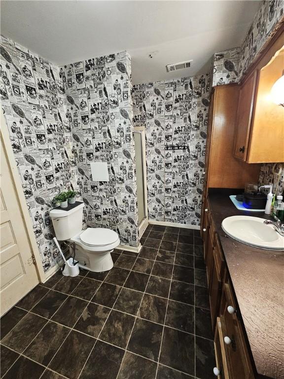 bathroom featuring vanity, tile patterned floors, and toilet