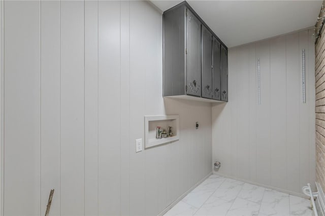 clothes washing area with electric dryer hookup, wooden walls, cabinets, and washer hookup