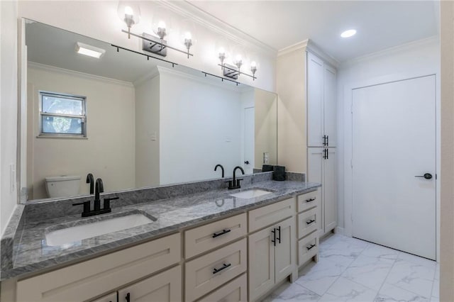 bathroom with toilet, vanity, and ornamental molding