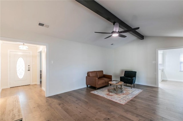 sitting room featuring lofted ceiling with beams, dark hardwood / wood-style floors, ceiling fan, and a healthy amount of sunlight