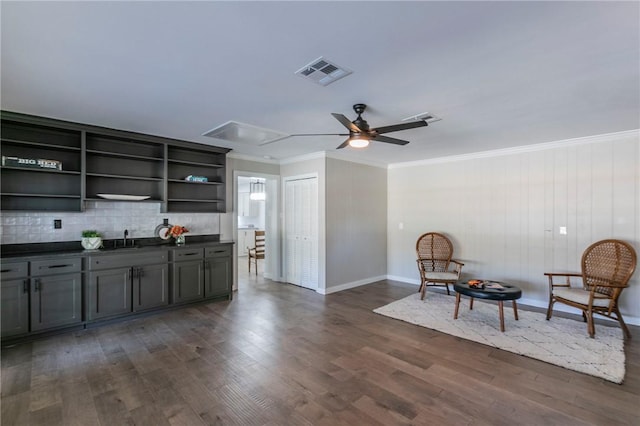 interior space with ceiling fan, sink, dark wood-type flooring, crown molding, and wood walls