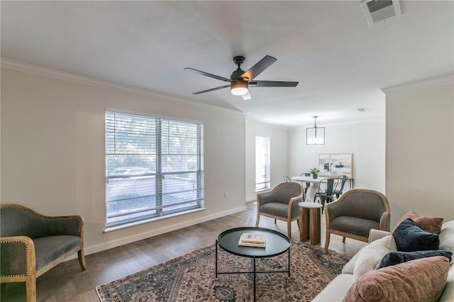 living room featuring crown molding, ceiling fan with notable chandelier, and dark hardwood / wood-style floors