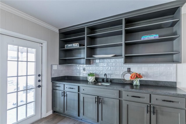 kitchen featuring backsplash, crown molding, sink, gray cabinets, and dark hardwood / wood-style floors