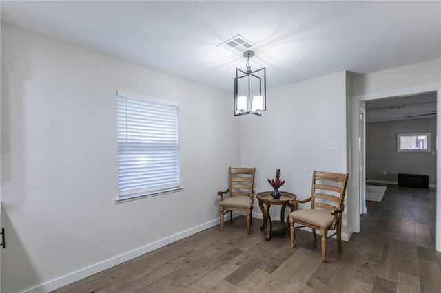 living area featuring dark wood-type flooring and an inviting chandelier