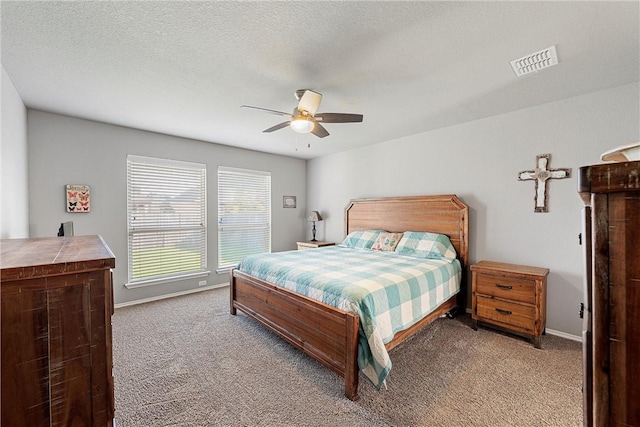 bedroom featuring a textured ceiling, ceiling fan, and light carpet