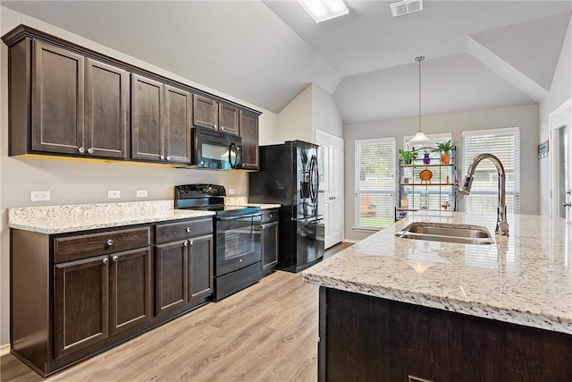 kitchen featuring dark brown cabinetry, light hardwood / wood-style flooring, decorative light fixtures, vaulted ceiling, and black appliances