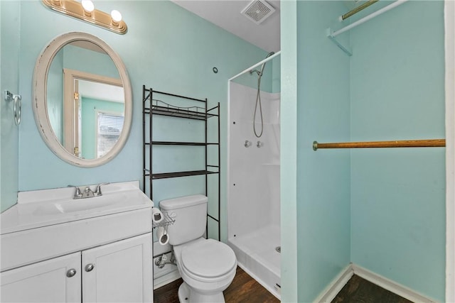 bathroom featuring a shower, vanity, hardwood / wood-style flooring, and toilet