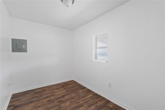 spare room featuring electric panel and dark hardwood / wood-style flooring