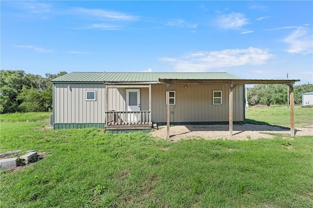 rear view of property featuring a lawn and a porch