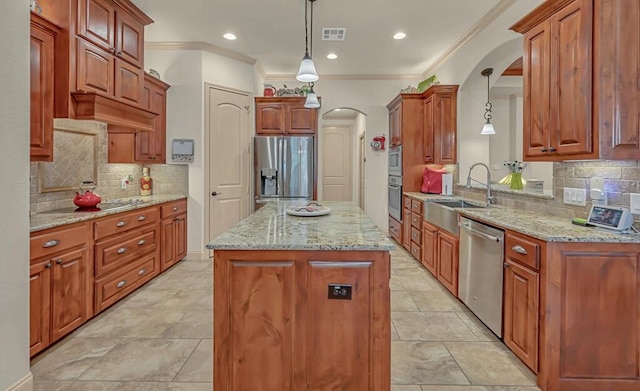 kitchen featuring pendant lighting, a center island, crown molding, sink, and appliances with stainless steel finishes