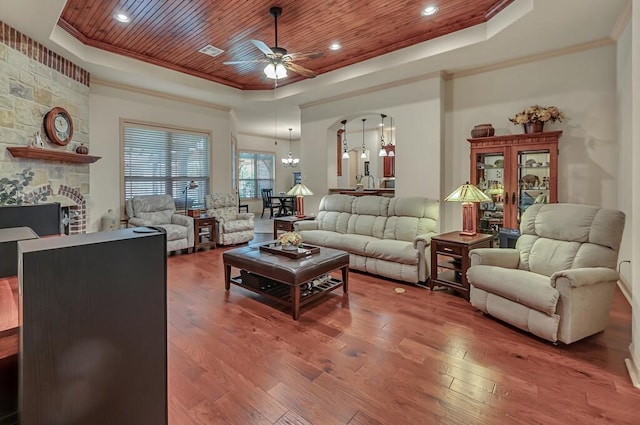 living room with a raised ceiling, wood ceiling, ceiling fan with notable chandelier, and hardwood / wood-style flooring