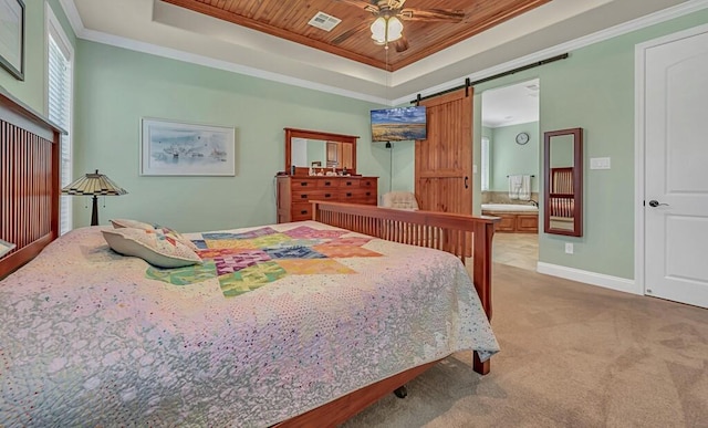 carpeted bedroom with connected bathroom, ceiling fan, a barn door, crown molding, and a tray ceiling