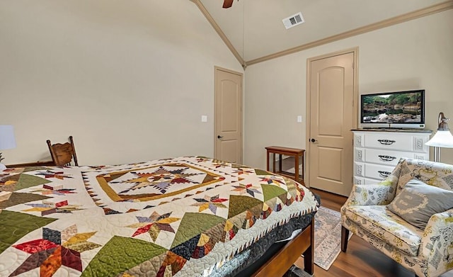 bedroom featuring ceiling fan, wood-type flooring, ornamental molding, and vaulted ceiling