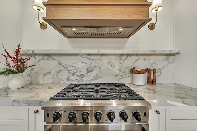 kitchen with decorative backsplash, appliances with stainless steel finishes, white cabinets, and light stone countertops