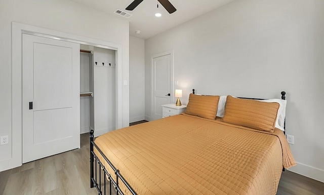 bedroom with a closet, light hardwood / wood-style flooring, and ceiling fan