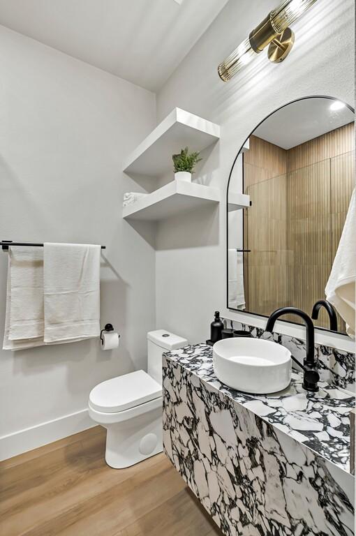 bathroom with hardwood / wood-style flooring, toilet, and sink