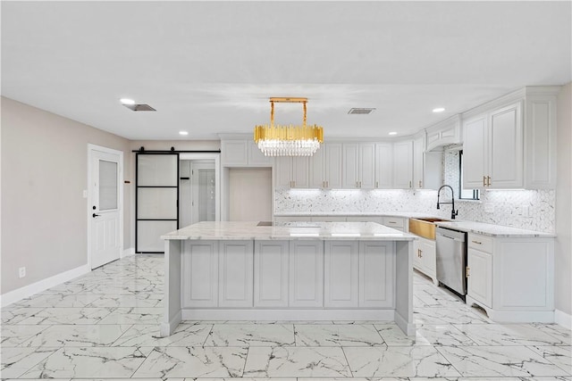 kitchen featuring pendant lighting, white cabinetry, a barn door, and a kitchen island