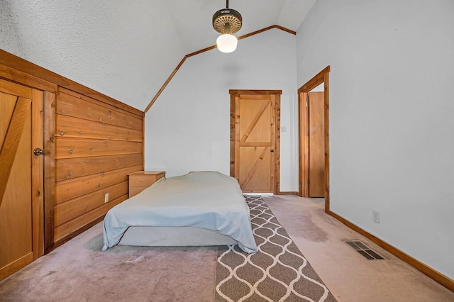 carpeted bedroom with high vaulted ceiling