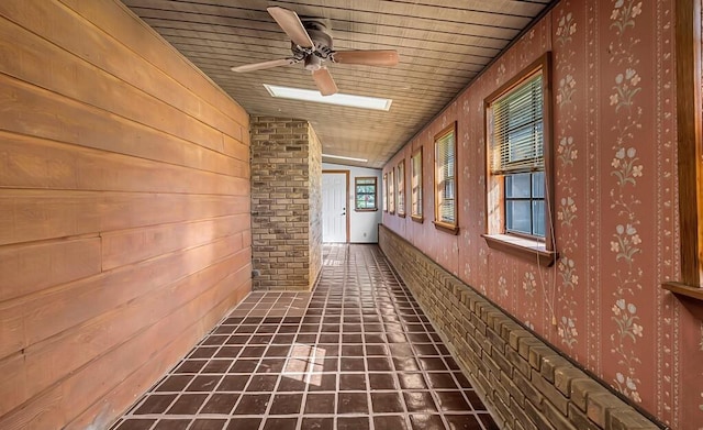 hall featuring lofted ceiling, wood ceiling, and dark tile patterned floors