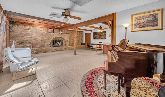 interior space featuring light tile patterned floors, ceiling fan, a fireplace, a textured ceiling, and brick wall