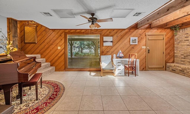 living area with ceiling fan, light tile patterned floors, and a textured ceiling