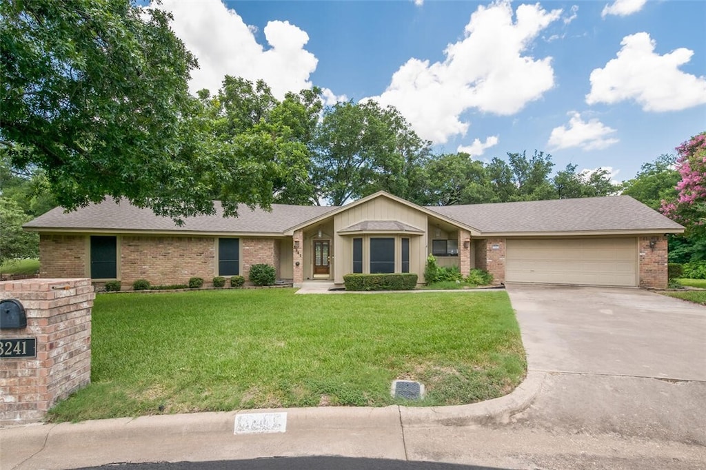 ranch-style home with a front lawn and a garage