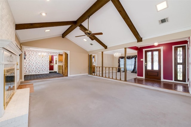 unfurnished living room with vaulted ceiling with beams, a fireplace, carpet floors, and ceiling fan with notable chandelier